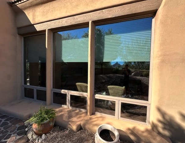 Large stucco-framed picture windows cleaned on a desert patio